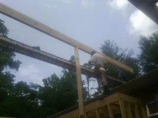 Carpenter setting a ridge beam over a new addition frame — Ice Dam Removal by Roofing Brothers in Chancellor