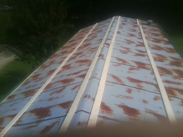 Rusted metal roof panels with new wood purlins before replacement — Storm Damage Roof Repair in Chancellor by Roofing Brothers
