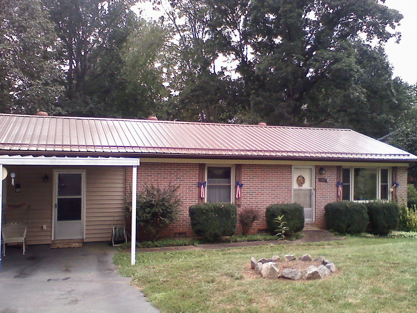 Bronze metal roof and carport on a brick ranch home — Roof Repair work by our crew in Chancellor